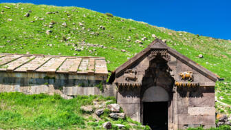 Eingang von einem grünen Hügel in der mittelalterliche Karawanserei von Prinz Orblian am Selimpass in Armenien