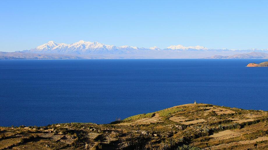 Blick von der Isla del Sol über den tiefblauen Titicacasee auf die Eisgipfel der Cordillera Real