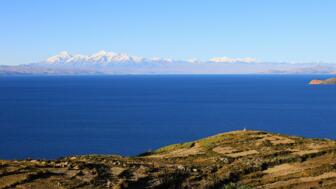 Blick von der Isla del Sol über den tiefblauen Titicacasee auf die Eisgipfel der Cordillera Real
