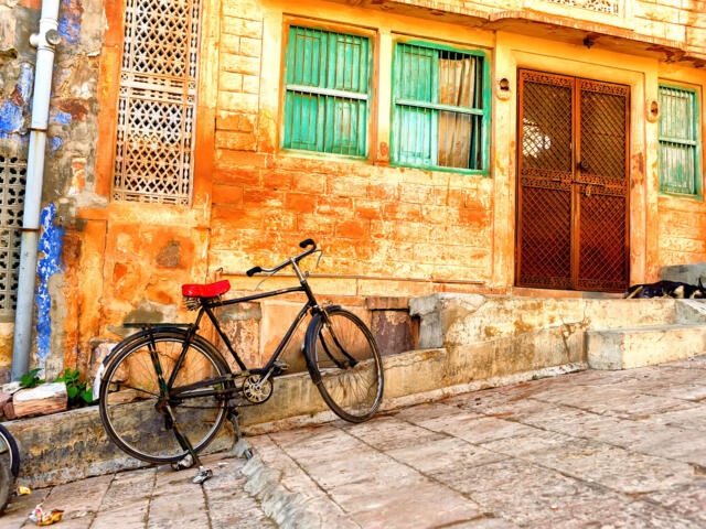 Traditionelle Straße in Rajasthan mit farbenfroher Fassade und einem abgestellten Fahrrad.