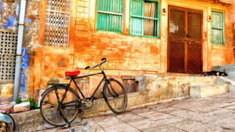 Traditionelle Straße in Rajasthan mit farbenfroher Fassade und einem abgestellten Fahrrad.