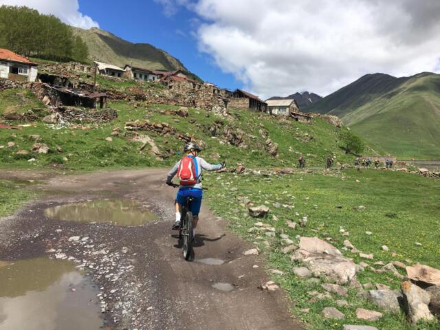 Ein Mountainbiker unterwegs auf einem Forststraße im Kaukasus in Georgien.