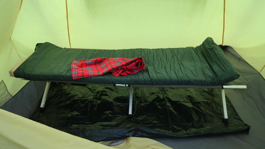 Zubuchbares Feldbett mit Isomatte in einem stehhohen Zelt für die Übernachtung im Kilimandscharo Nationalpark