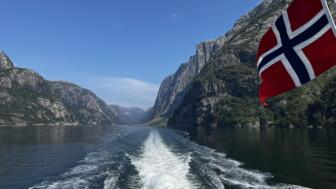 Blick nach hinten von einer fahrenden Fähre durch den Fjord