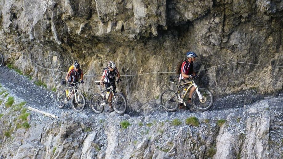 Einen Mountainbike Gruppe unterwegs durch die weltberühmte Uina-Schlucht während einer Schiebepassage.