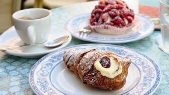 Ein Tisch mit frischen Nachspeisen, Croissan, Kuchen und ein Espresso