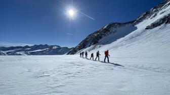 Skitourengruppe im Aufstieg bei bestem Wetter